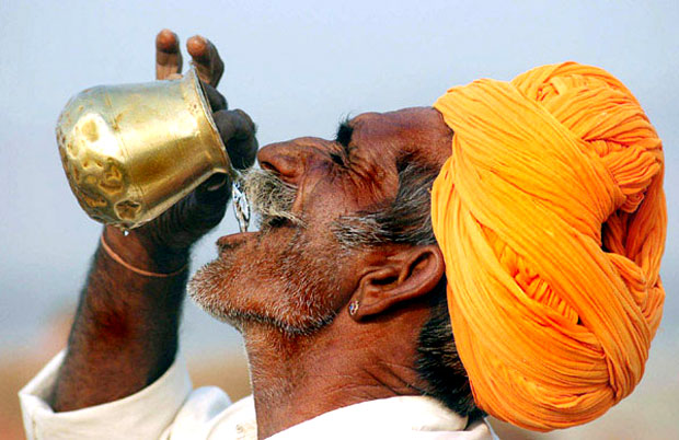 Man drinking water on copper pot