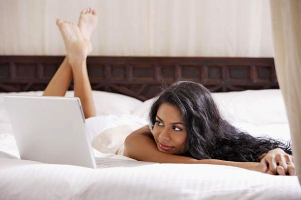 girl using laptop in bed